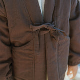 Close-up of the Amélie Coat in Cacao brown, showing the front tie closure and large patch pockets.