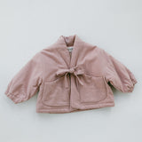 A dusty pink cropped jacket with a tie-front closure and front patch pockets, laid flat on a light gray background.